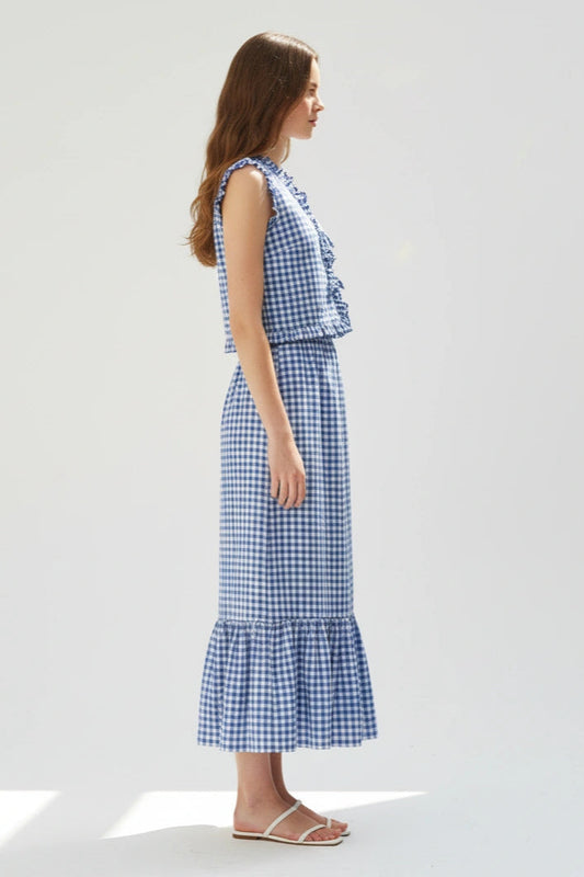 Woman wearing a blue and white checkered dress on a white background